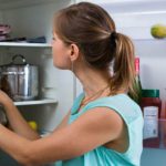 chica escogiendo alimentos del refrigerador
