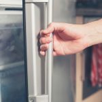 persona abriendo puerta de la refrigeradora