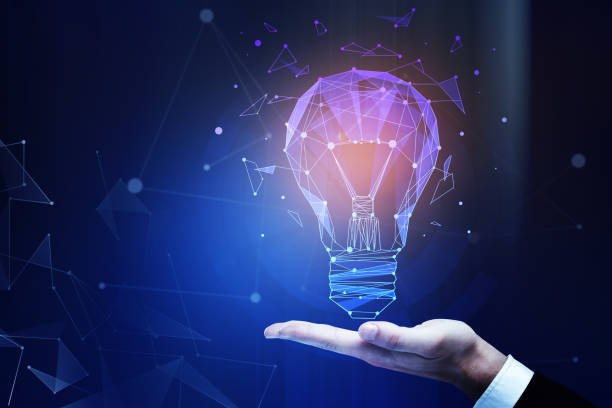 Businessman's hand holding abstract creative illuminated polygonal lamp on dark background with copy space. Imagination concept. 3D Rendering