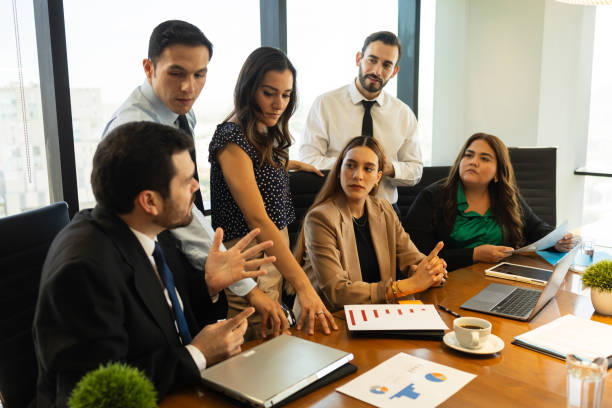 Diverse group of people doing some work in a meeting room and reviewing some documents together