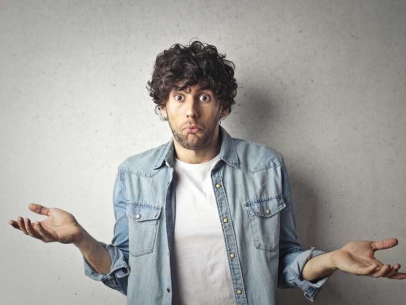 Man shrugging with a confused expression, representing uncertainty about a suspicious “easy money” offer