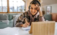 Person studying at a desk and taking notes, focused on learning a new skill.