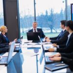 Corporate board members reviewing information during a governance meeting.