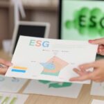 Finance professionals reviewing sustainable finance targets and ESG performance metrics during a business meeting.