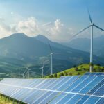 Solar panels and wind turbines installed across a landscape, illustrating the diversification of renewable energy sources in Central America.